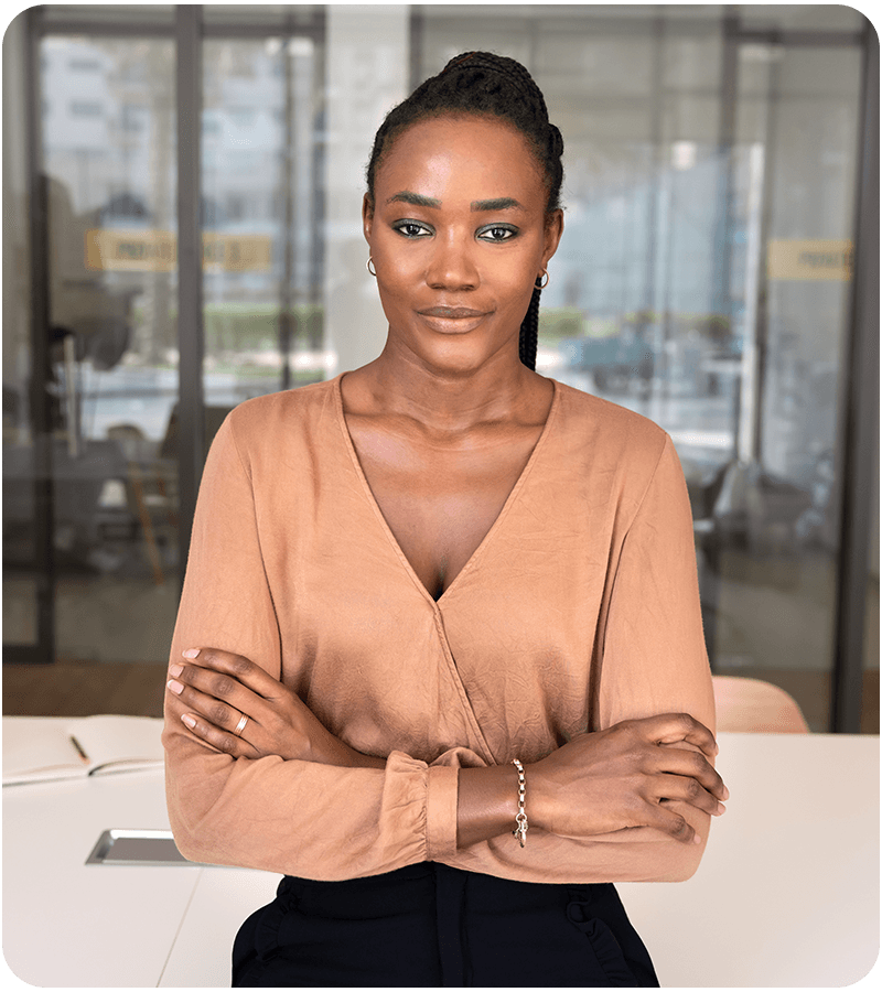 Professional woman standing with arms crossed in a modern office